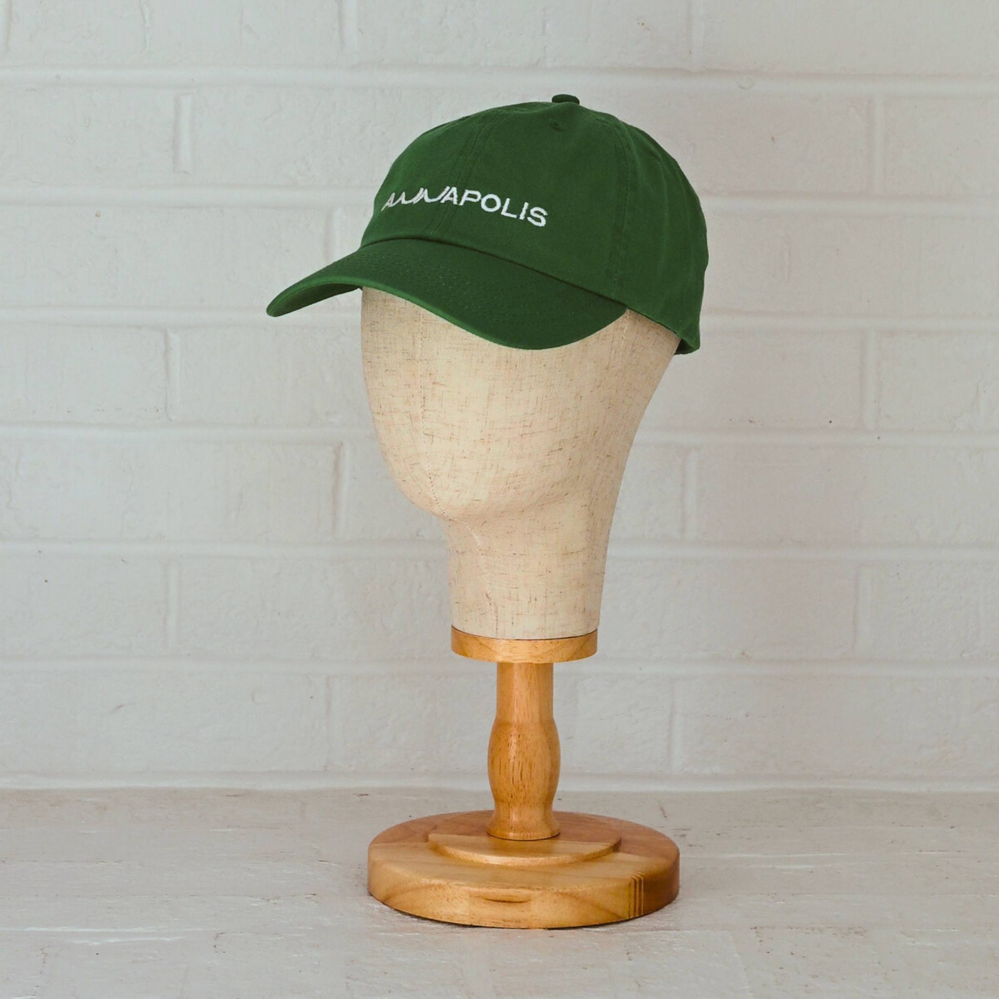 Kelly green low-profile unstructured dad hat with white embroidered Annapolis script.