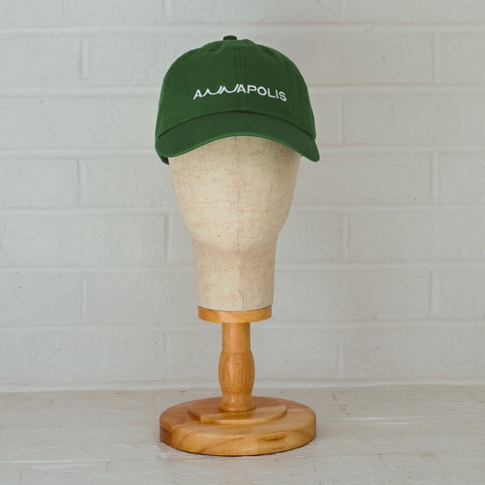 Kelly green low-profile unstructured dad hat with white embroidered Annapolis script.